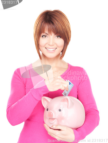 Image of lovely woman with piggy bank and money