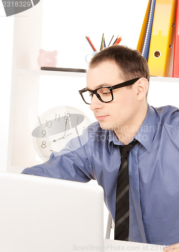 Image of businessman with laptop computer in office