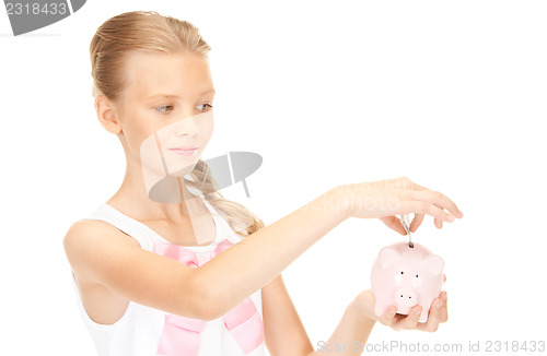 Image of lovely teenage girl with piggy bank and money