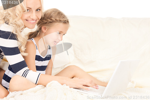 Image of happy mother and child with laptop computer