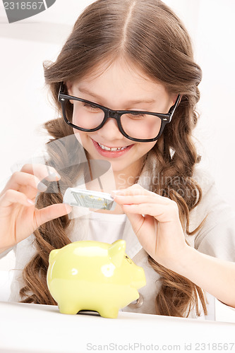 Image of little girl with piggy bank and money