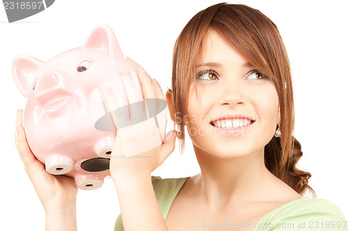 Image of lovely teenage girl with piggy bank