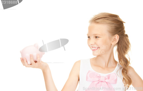 Image of lovely teenage girl with piggy bank