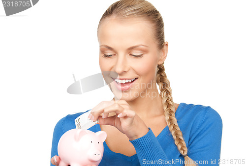 Image of lovely woman with piggy bank and money