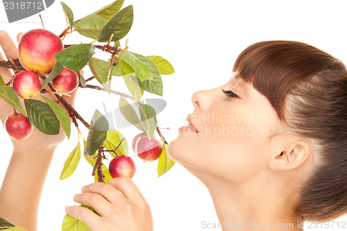 Image of happy woman with apple twig