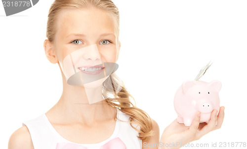 Image of lovely teenage girl with piggy bank and money