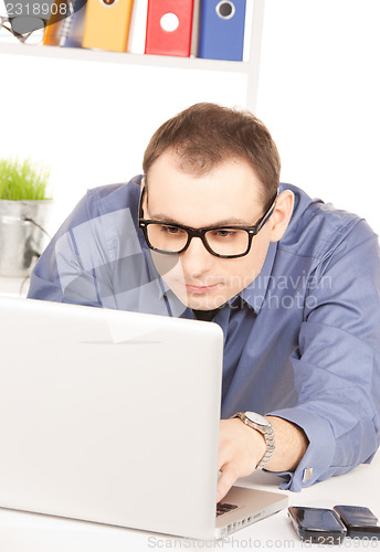 Image of businessman with laptop computer in office