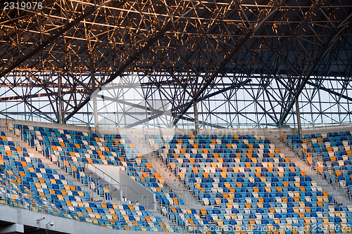 Image of Tiered seats sit empty in large sports stadium