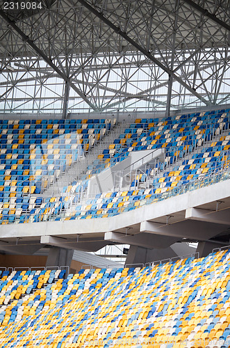 Image of Tiered seats sit empty in large sports stadium