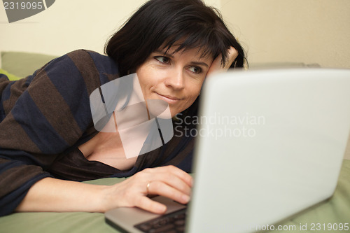 Image of Woman with laptop on sofa