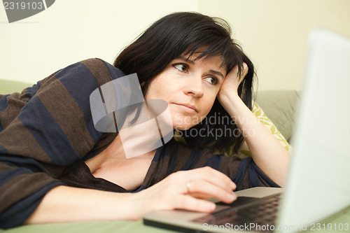 Image of Woman with laptop on sofa