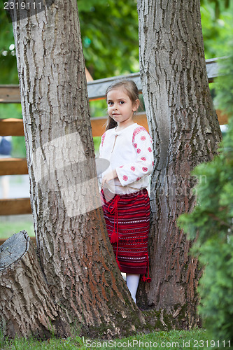 Image of Cute little girl among the trees