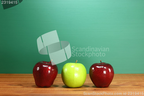 Image of School Apples Sitting on Teacher Desk in a Row