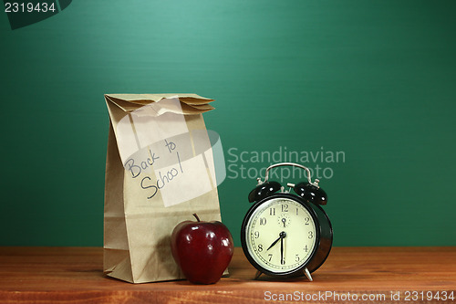 Image of School Lunch, Apple and Clock on Desk at School