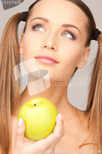 Image of young beautiful woman with green apple
