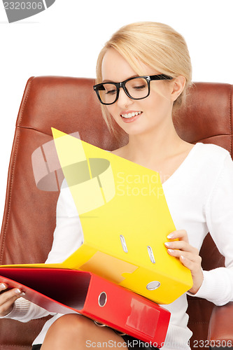 Image of young businesswoman with folders sitting in chair