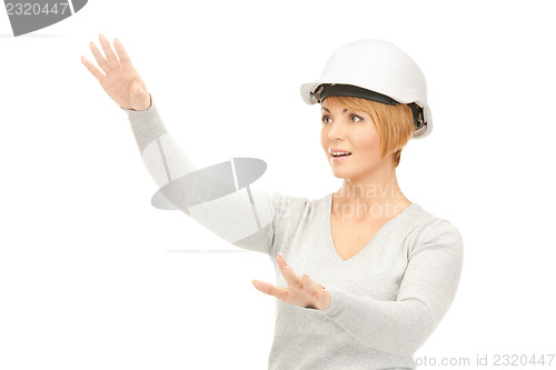 Image of female contractor in helmet working with something imaginary