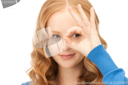 Image of lovely woman looking through hole from fingers