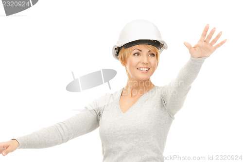 Image of female contractor in helmet working with something imaginary