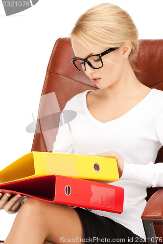 Image of young businesswoman with folders sitting in chair