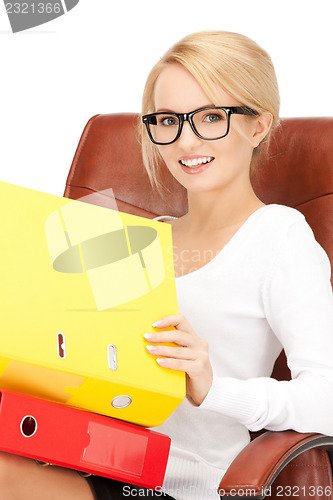 Image of young businesswoman with folders sitting in chair