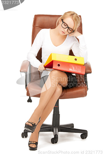 Image of young businesswoman with folders sitting in chair