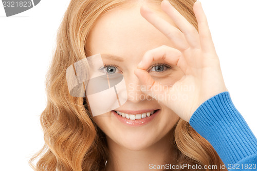 Image of lovely woman looking through hole from fingers