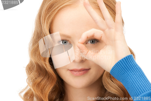 Image of lovely woman looking through hole from fingers