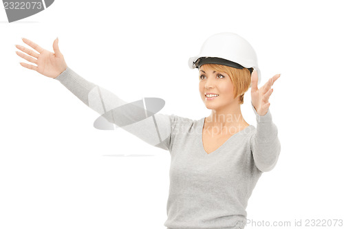 Image of female contractor in helmet working with something imaginary