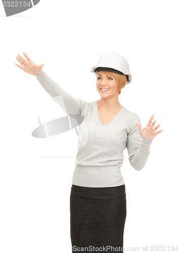 Image of female contractor in helmet working with something imaginary