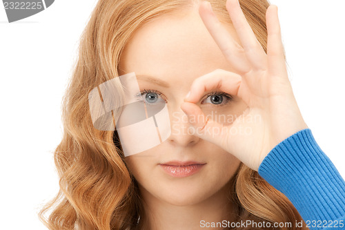 Image of lovely woman looking through hole from fingers