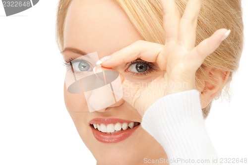 Image of lovely woman looking through hole from fingers