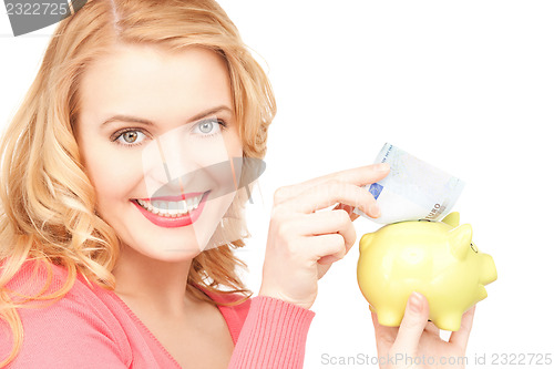 Image of lovely woman with piggy bank and money