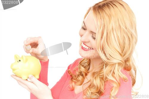 Image of lovely woman with piggy bank and money