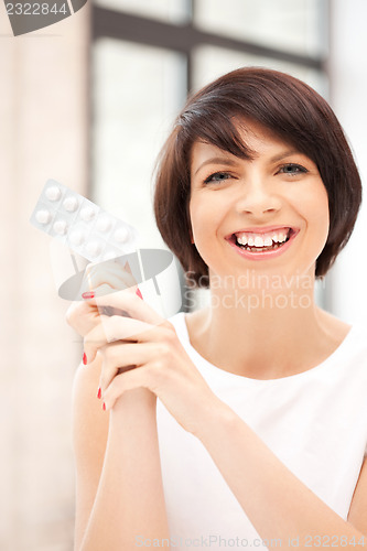 Image of young beautiful woman with pills