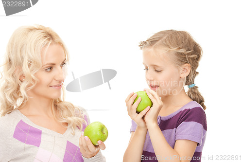 Image of mother and little girl with green apple