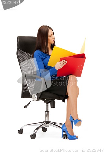 Image of young businesswoman with folders sitting in chair