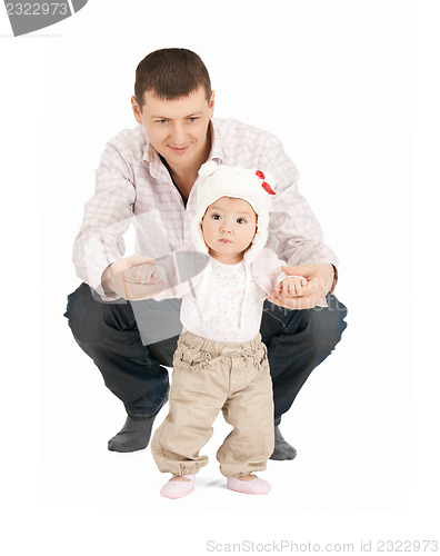 Image of baby making first steps with father help