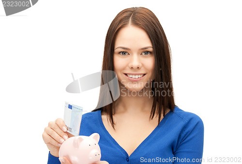 Image of lovely woman with piggy bank and money