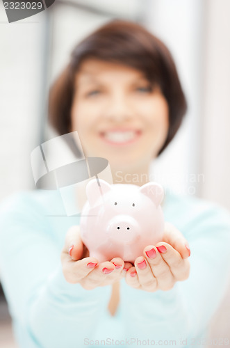 Image of lovely woman with piggy bank