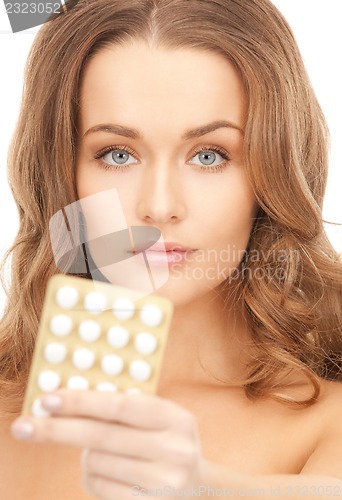 Image of young beautiful woman with pills