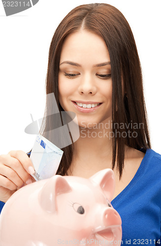 Image of lovely woman with piggy bank and money