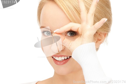 Image of lovely woman looking through hole from fingers