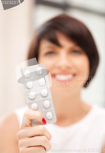 Image of young beautiful woman with pills