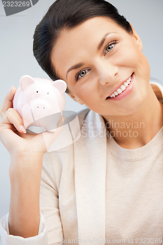 Image of lovely woman with piggy bank