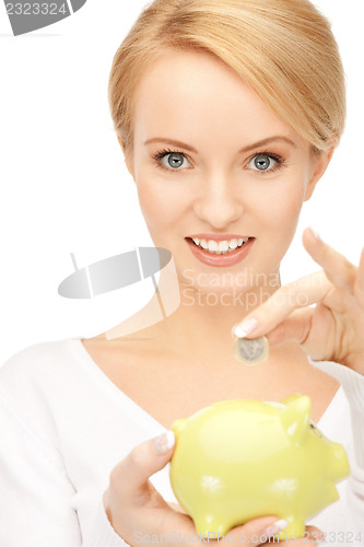 Image of lovely woman with piggy bank and money