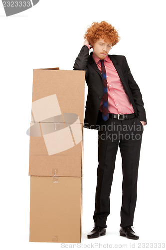 Image of attractive businessman with big boxes