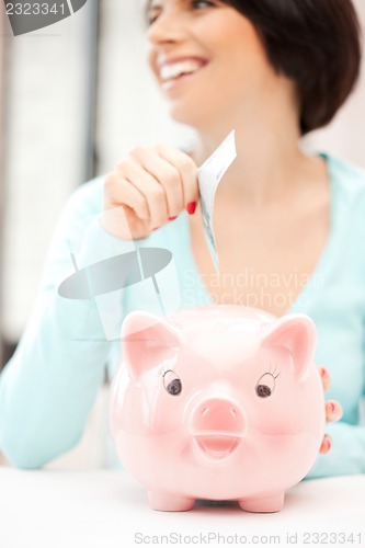 Image of lovely woman with piggy bank and money