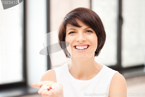 Image of young beautiful woman with pills