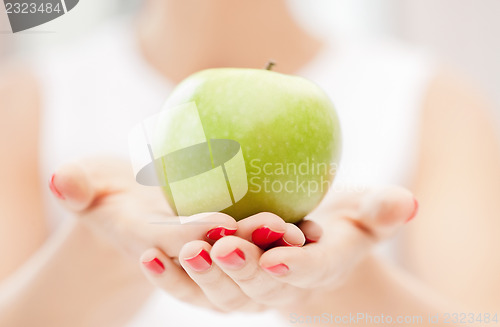 Image of female hands with green apple